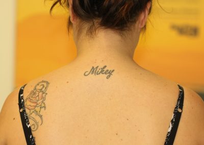 Black name neck tattoo before laser tattoo removal