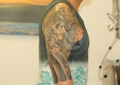 Large black sleeve tattoo before treatment