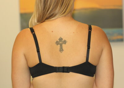 Black Cross Tattoo on mid back before
